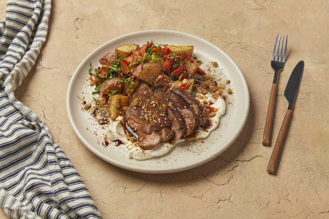 Carved grilled lamb over labneh with batata harra and dukkah