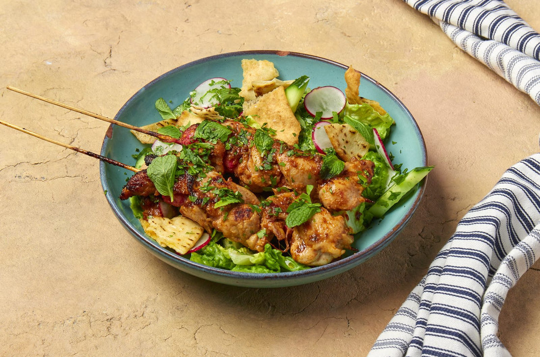 Chicken shish tawook skewers over fattoush salad with crispy pitta