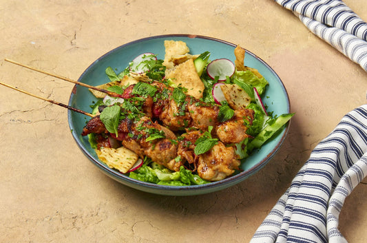 Chicken shish tawook skewers over fattoush salad with crispy pitta